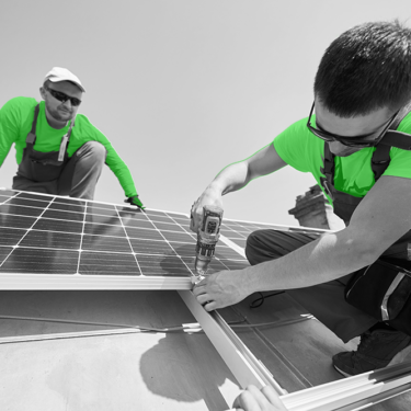 Zwei Ingenieure arbeiten auf einem Dach an der Installation von Solarzellen